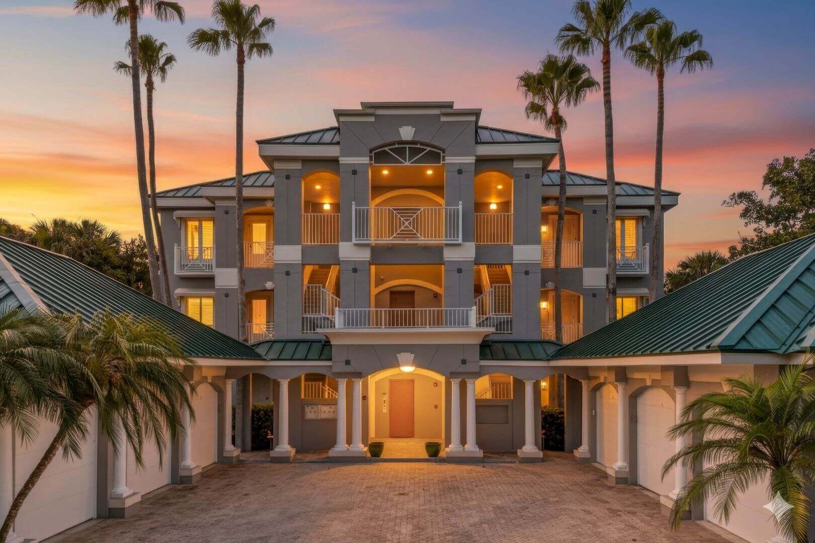 Elegant house with palm trees at sunset.