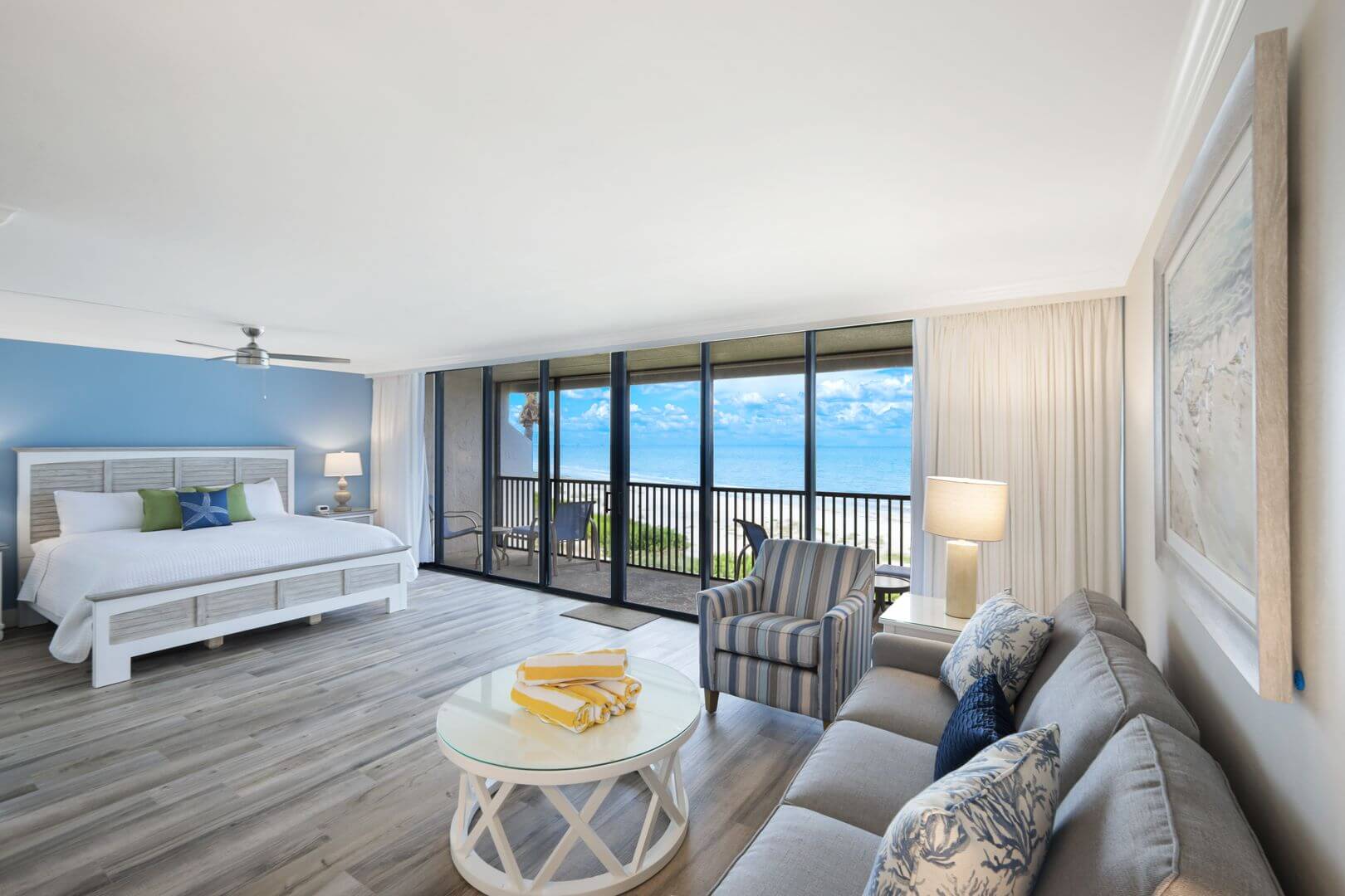 Spacious hotel room with ocean view balcony.