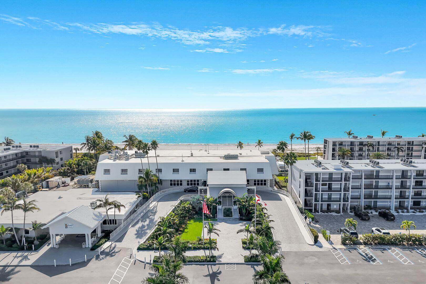 Beachfront resort with ocean view and palm trees.