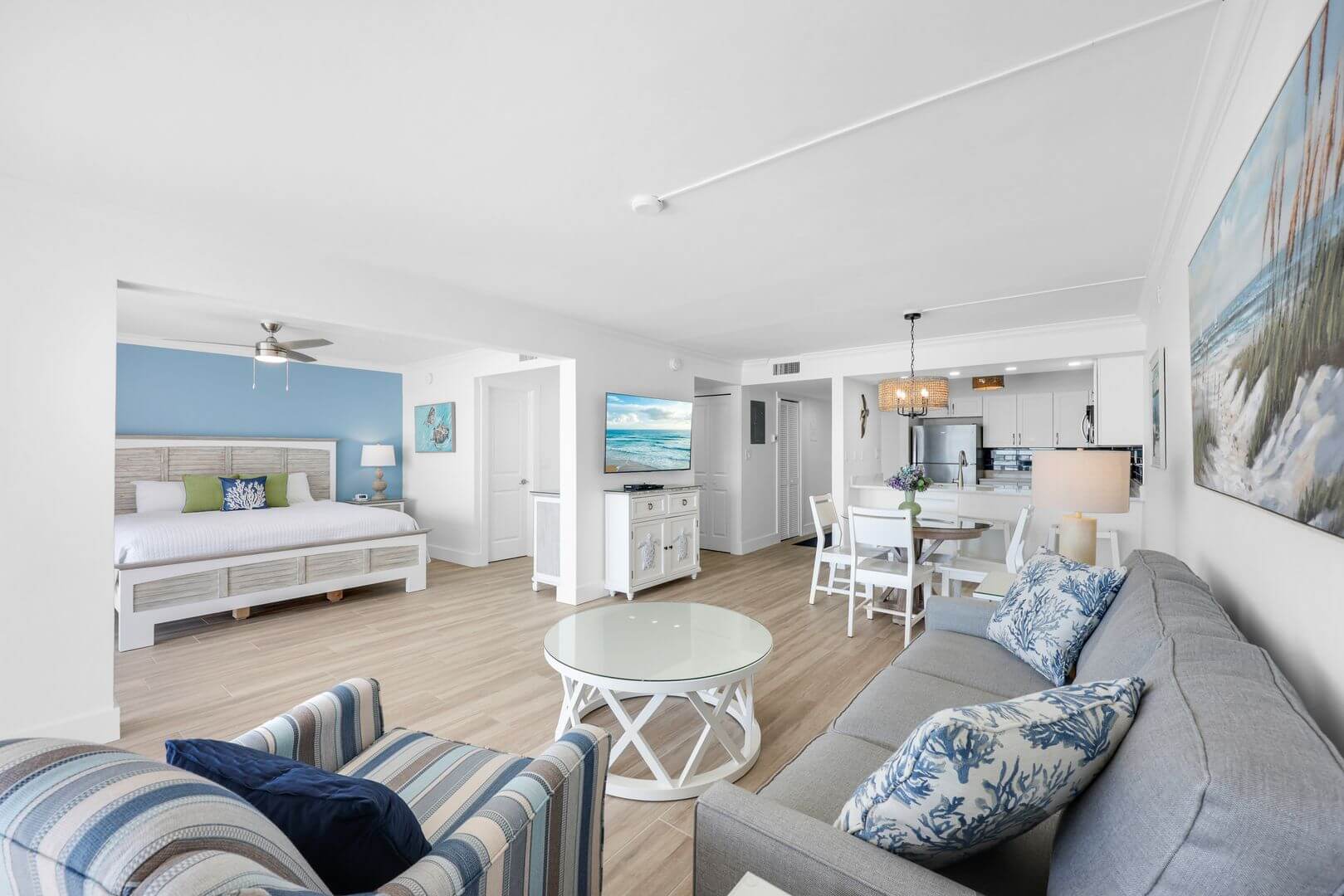 Open-plan coastal-themed living and bedroom area.