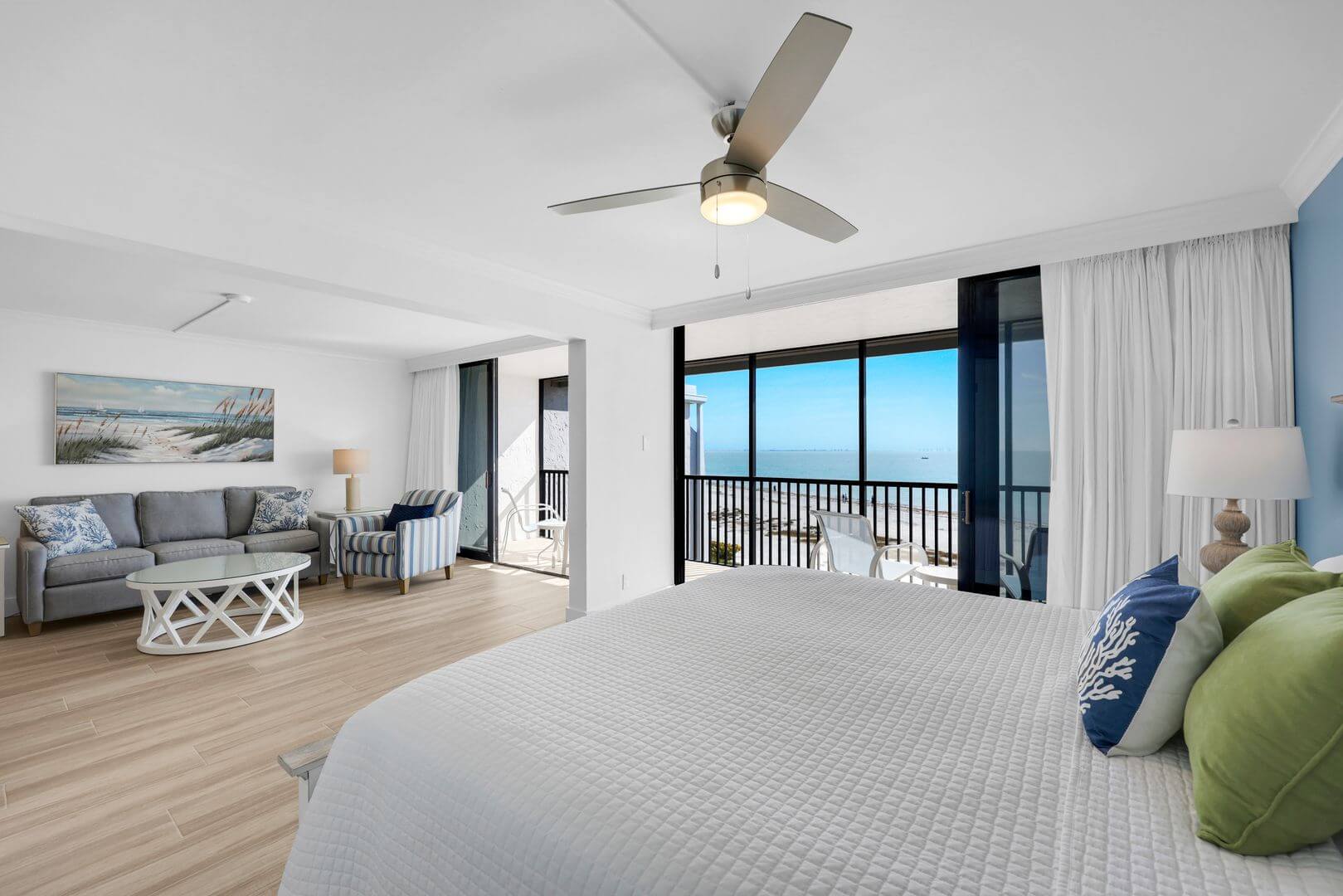 Modern hotel room with ocean view balcony.