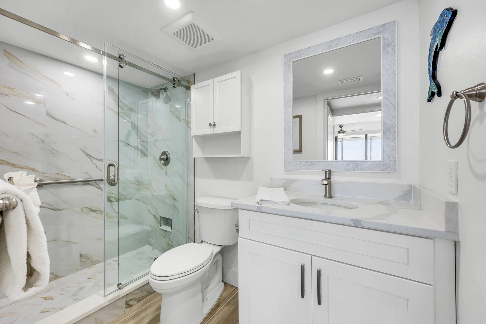Modern white bathroom with glass shower door.