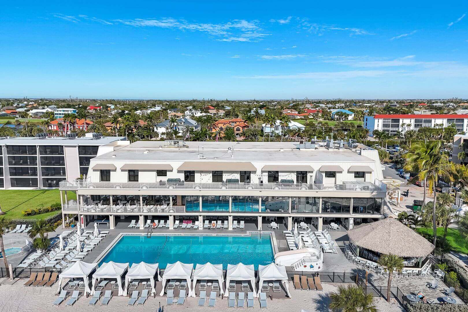 Hotel with pool and cabanas, aerial view.