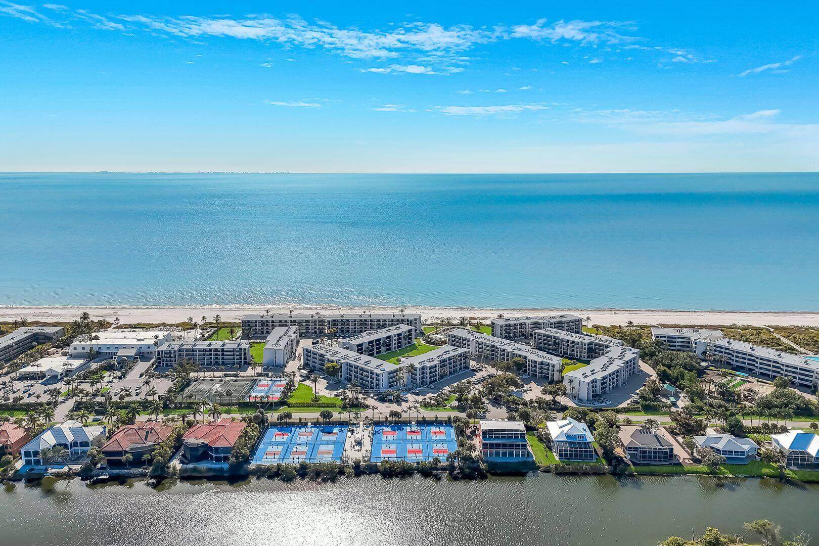 Coastal resort with tennis courts and ocean.