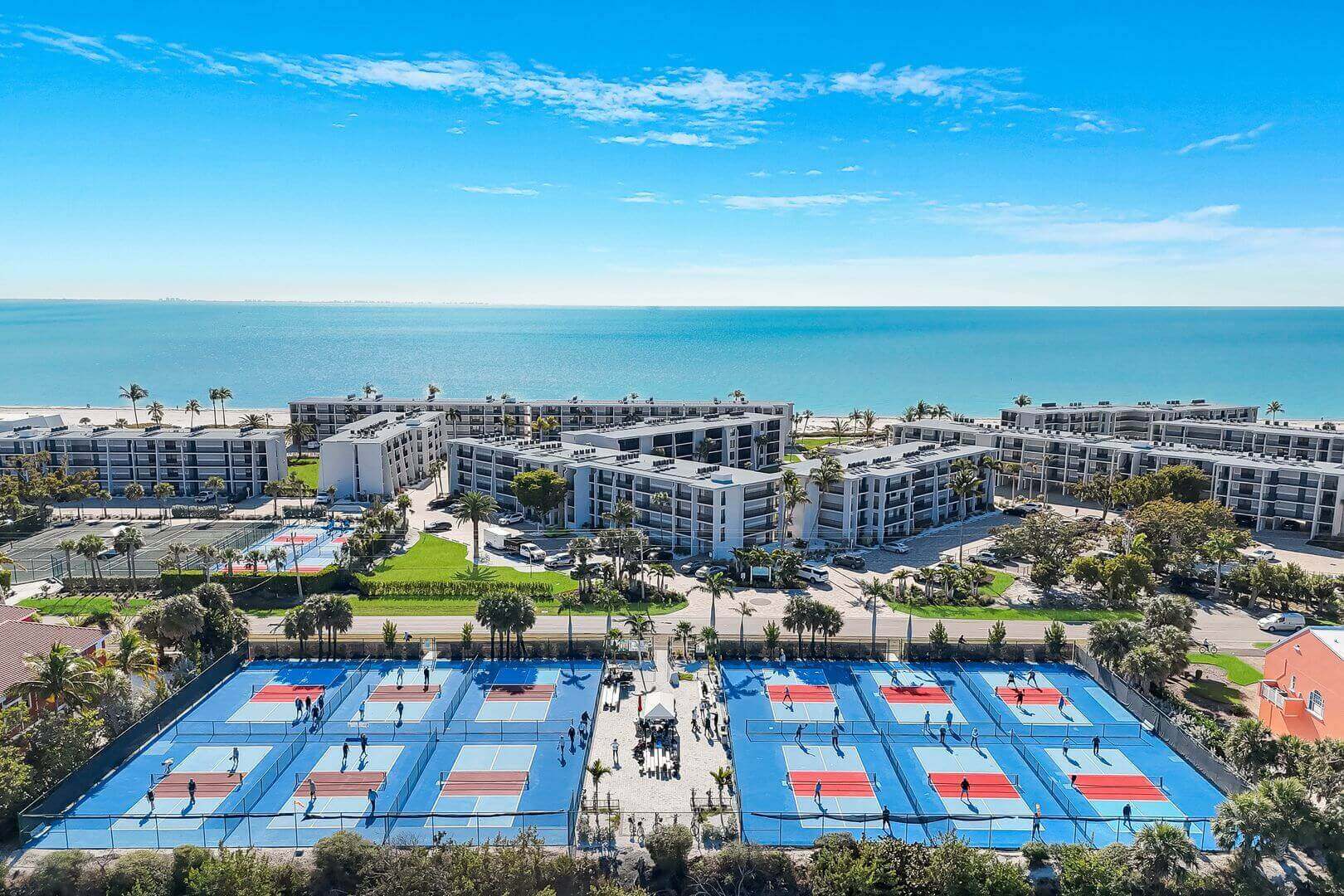 Tennis courts near beachfront residential buildings.