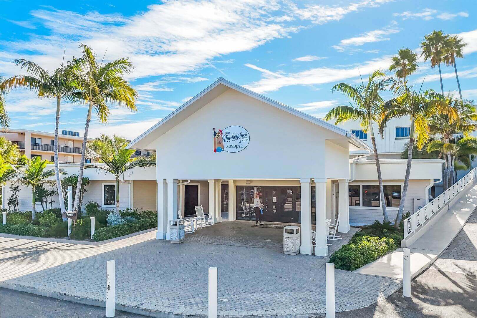 Beachfront building with palm trees and sky.