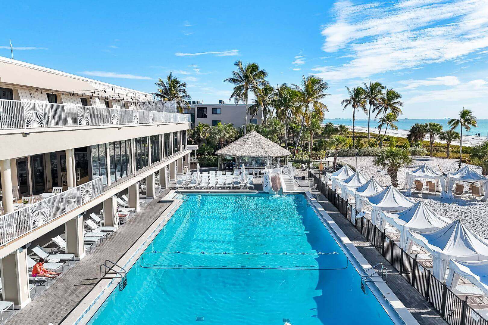 Beachfront resort with pool and palm trees.